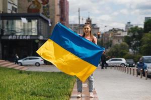 Young woman with national flag of Ukraine on the street photo