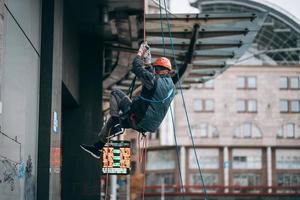 Industrial climber in uniform and helmet rises photo