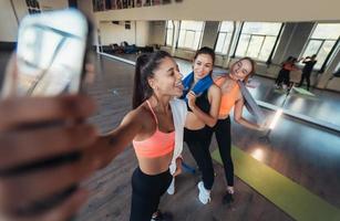 Two female friends taking a selfie photo after hard workout.