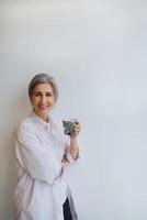 Portrait of elderly female in casual casual wear holding a mug photo