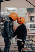 chico y chica con cabezas de calabaza se miran foto