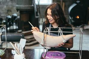 Portrait of young woman enjoying favorite job in workshop. photo