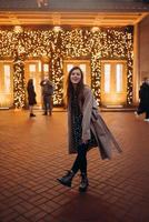 Girl on the background of the illuminated entrance to the building photo