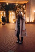 Girl on the background of the illuminated entrance to the building photo