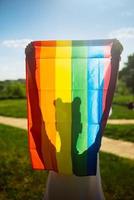 mujer joven sosteniendo una bandera del orgullo lgbt en sus manos. foto