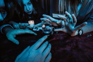 Group of people and woman fortune teller with crystal ball photo