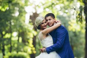 Beautiful wedding couple hugging in the park photo