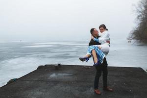 Beautiful couple on the dock in the winter fog. photo