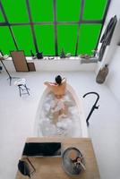 Relaxed lady taking bath, enjoying and relaxing while lying in bathtub, top view photo