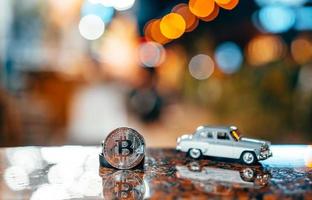 Silver bitcoin and Moskvich 401 on the table, glowing background photo