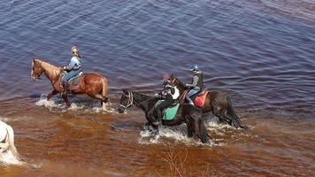 gente a caballo en la orilla del lago foto