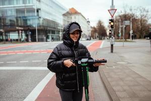 hermosa joven montando un scooter eléctrico, al estilo de la calle foto