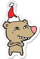 sticker cartoon of a bear showing teeth wearing santa hat vector