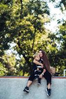 bella joven hipster mamá e hijo pequeño en el skatepark foto