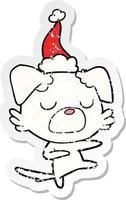 distressed sticker cartoon of a dog wearing santa hat vector