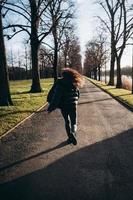 Portrait of a brunette girl having fun in a park in the rays of the bright sun. photo