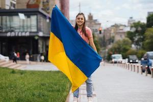 Young woman with national flag of Ukraine on the street photo