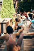 A woman does yoga together with her group in the open air photo