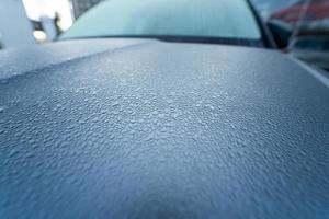 Raindrops on the hood of the car. Close-up. photo