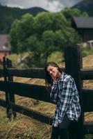 A young attractive Caucasian female stand by a fence photo