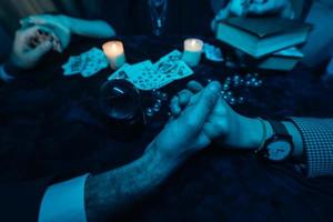 People hold hands of night at table with candles photo