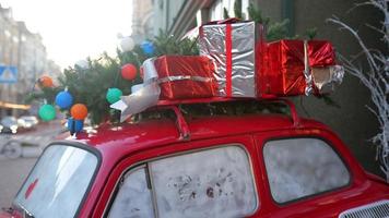 Red retro car with a Christmas tree fir tied to the roof. photo