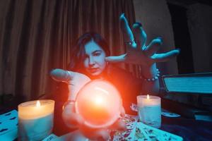 Woman fortune-teller guesses fate of night at table with candles photo