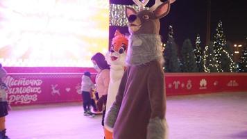 People enjoy ice skating in the street around Christmas tree in rink. photo