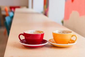 Two cups of cappuccino on wooden table in cafe. photo