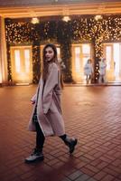 Girl on the background of the illuminated entrance to the building photo