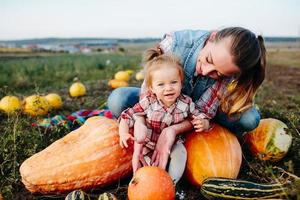 madre e hija sentadas en calabazas foto