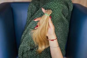 mujer joven sosteniendo su cabello castaño largo recién cortado en colas de caballo foto