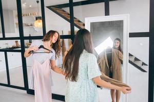 Two women choose and try on clothes at home photo