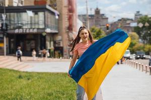 Young woman with national flag of Ukraine on the street photo