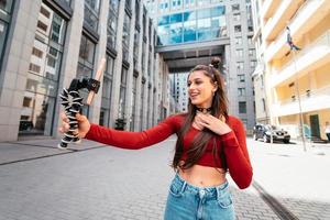 Young female blogger with smartphone streaming on the street. photo