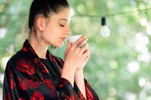 foto de una joven bebiendo de un tazón de té