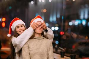 Portrait of happy cute young friends hugging each other at caffe. photo