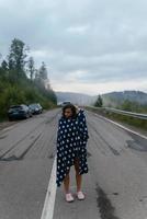 Tourist woman walking on a highway in the mountains photo