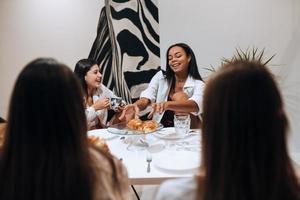 Grupo de amigas disfrutando de comida en casa foto