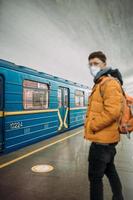 Guy standing at station in medical protective mask on his face. photo