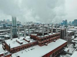 Large central boiler room with giant pipes of which there is dangerous smoke in winter during frost in a big city photo