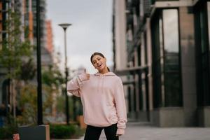 Playful portrait of pretty young woman, having fun at the street. photo