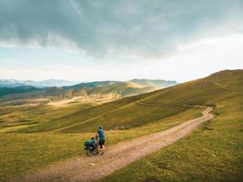 Aerial circle around happy fit cyclist person outdoors enjoy fresh mountains air in nature . Healthy lifestyle, inspirational, motivational sportsman adventurous lifestyle photo