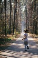 bella joven corriendo en un parque verde en un día soleado de verano foto