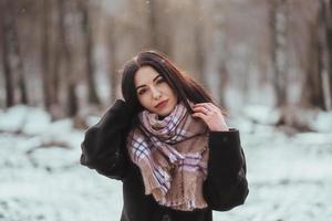 Young beautiful model posing in winter forest. stylish fashion portrait photo