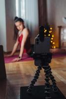 Young woman practicing yoga, is engaged with the teacher online. photo