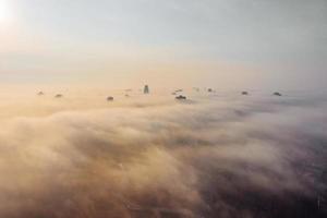 Aerial view of the city in the fog. Skyscrapers above the fog photo