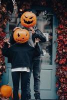 pareja con cabezas de calabaza asusta a los transeúntes en la cámara foto