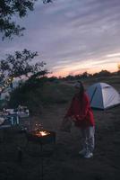 mujer joven preparando comida a la parrilla junto al mar foto