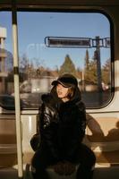 mujer joven sentada en el fondo de una ventana en transporte público foto